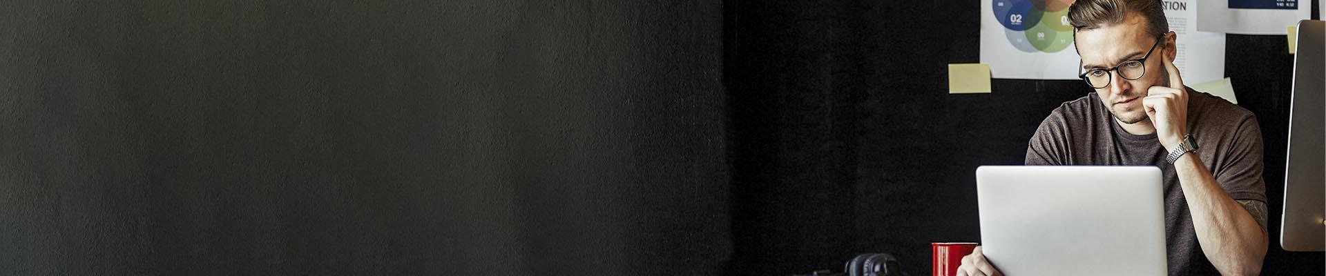 Recruit a junior image Man with glasses in front of a laptop