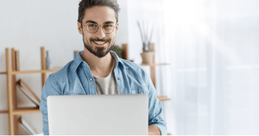 A smiling man with glasses and laptop