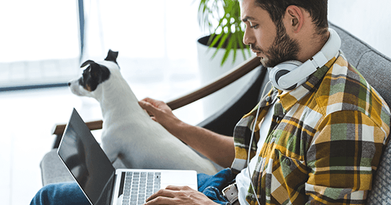 Man with a laptop and a dog.png Man sitting in front of a laptop with a dog